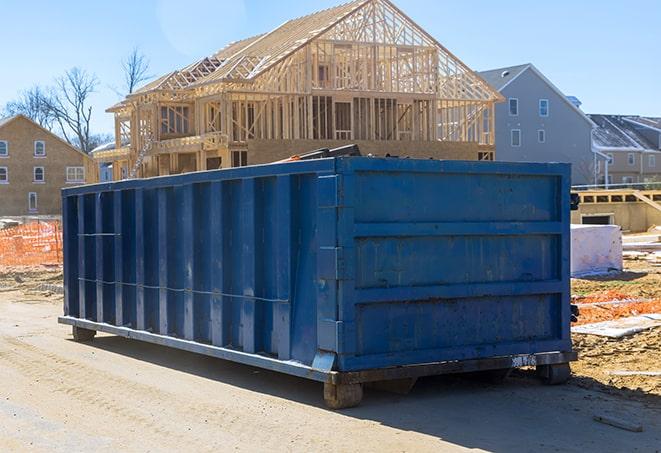 a row of residential dumpsters lined up outside a home